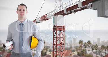 Confident architect with blueprints by crane