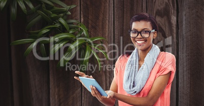 Smiling businesswoman using tablet PC against wall