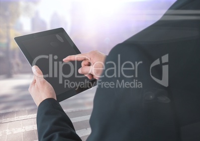Man over shoulder with tablet against blurry street with flares