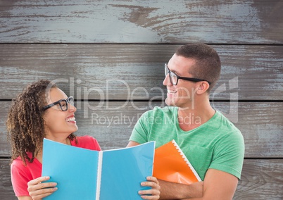 Happy business colleagues holding files against wooden wall