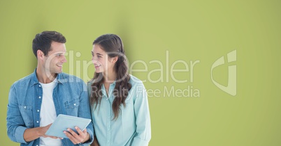 Male and female hipsters with digital tablet against green background