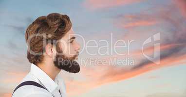Side view of male hipster looking away against cloudy sky