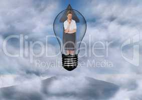 Businesswoman standing in bulb against sky