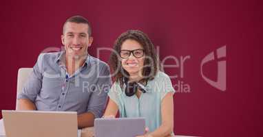 Casual business people with technologies over maroon background