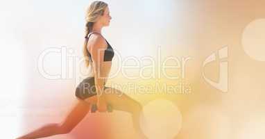 Side view of woman exercising by bokeh