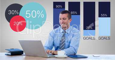 Smiling businessman using laptop by graphics