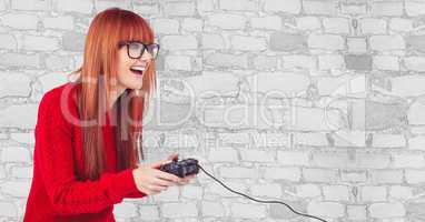 Happy female hipster playing video game against wall