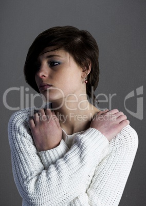 Woman with arms crossed against grey wall