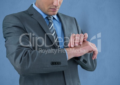Midsection of businessman touching wrist over blue background