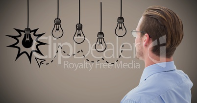 Business man looking at lightbulb graphics against brown background