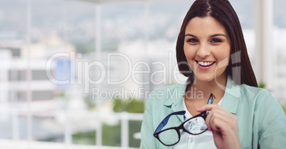 Smiling businesswoman holding eyeglasses in office
