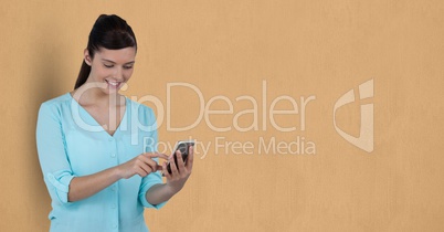 Businesswoman using mobile phone over beige background