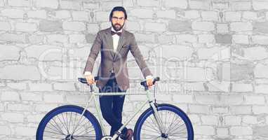 Hipster standing with bicycle against wall