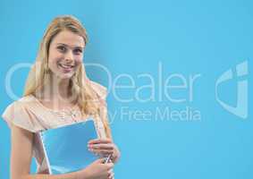 Portrait of woman holding book against blue background