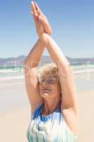 Close up of senior woman exercising while standing at beach