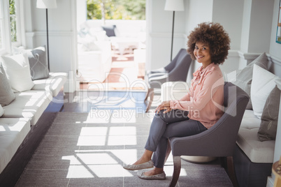 Portrait of beautiful woman sitting on arm chair