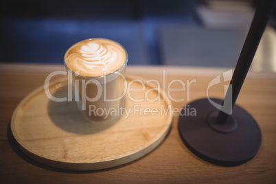 Delicious cappuccino glass on tray at counter