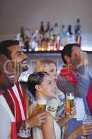 Smiling group of friends having beer while watching match