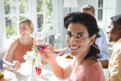 Smiling woman holding glass of red wine