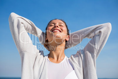 Low angle view of woman with hands behind head