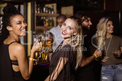 Portrait of female friends having drink at counter