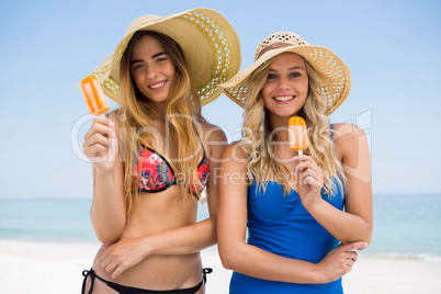 Portrait of female friends holding popsicles