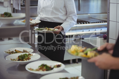 Chefs holding his food plates in the commercial kitchen