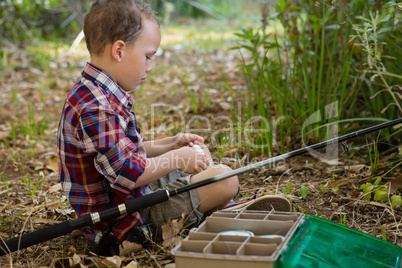 Boy preparing a bait in the forest