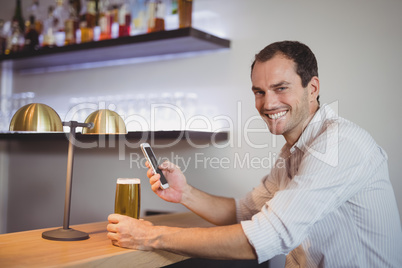 Man using mobile phone while having beer