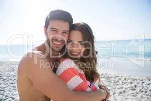 Portrait of smiling young couple embracing at beach