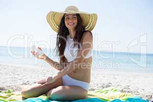 Portrait of smiling woman applying sunscream