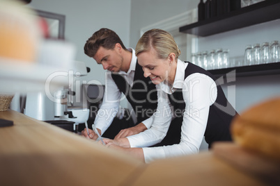 Waiter and waitress working at counter