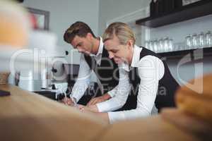 Waiter and waitress working at counter