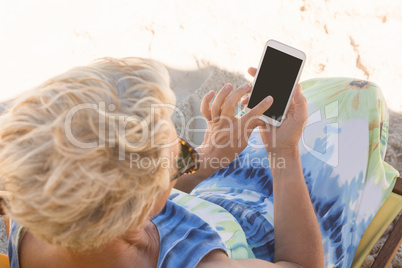 High angle view of woman using smart phone while sitting on chair