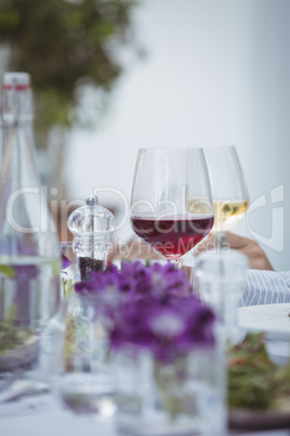 Close-up of red wine glass, salt and pepper shaker on table