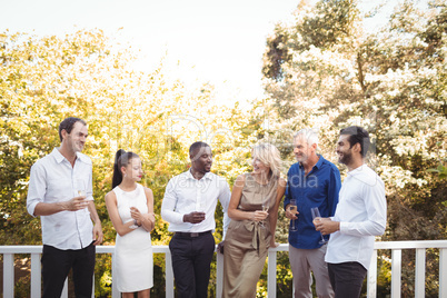 Friends interacting with each other while having champagne in balcony