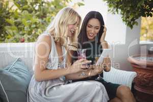 Smiling womens using mobile phone