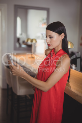 Woman using mobile phone at counter