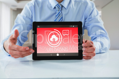 Composite image of businessman showing digital tablet