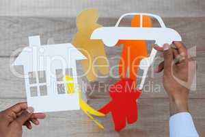 Composite image of man holding a car and a house in paper