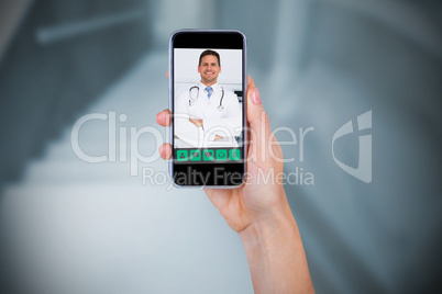 Composite image of hand holding mobile phone against white background