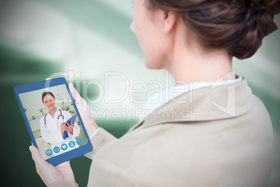 Composite image of businesswoman holding digital tablet on white background