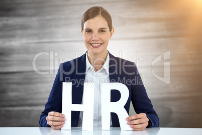 Composite image of business woman smiling and holding letters h and r