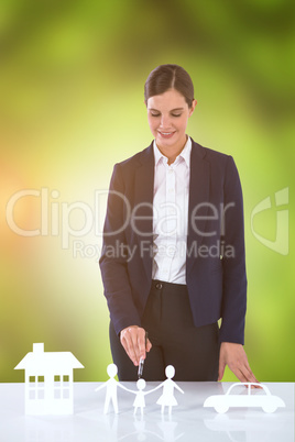 Composite image of woman drawing a car, a family and a house
