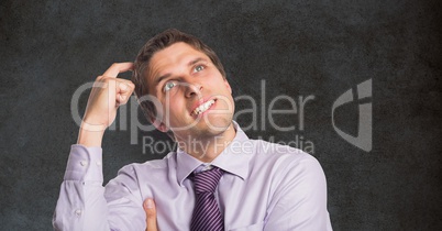 Confused businessman scratching head against blackboard