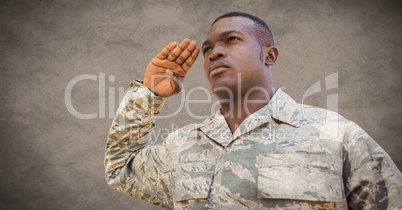 Soldier saluting against brown background with grunge overlay