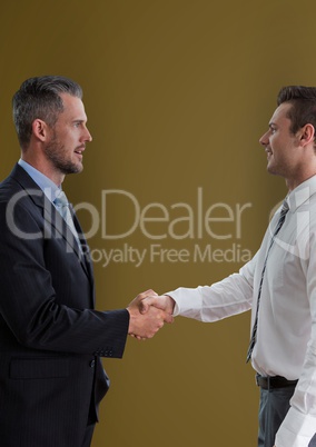 Side view of businessmen shaking hands against green background