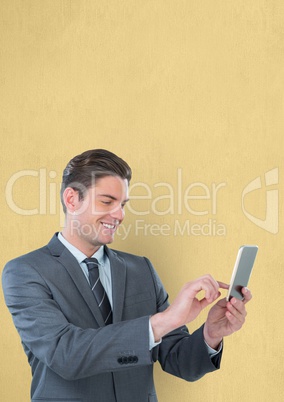 Smiling businessman using smart phone over yellow background