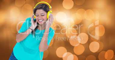 Smiling woman listening to music on headphones against bokeh