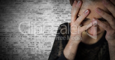 Woman hands over face against white brick wall with grunge overlay